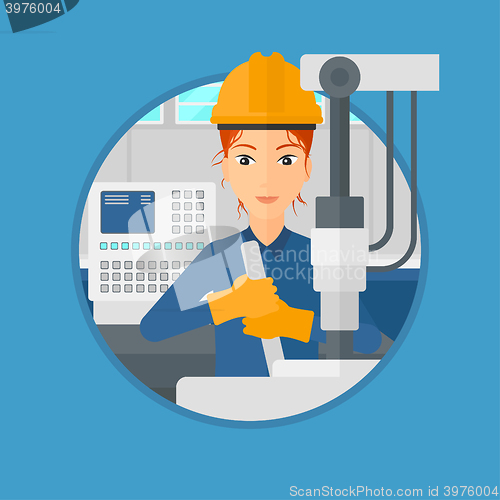 Image of Woman working on industrial drilling machine.