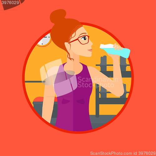 Image of Sportive woman drinking water.
