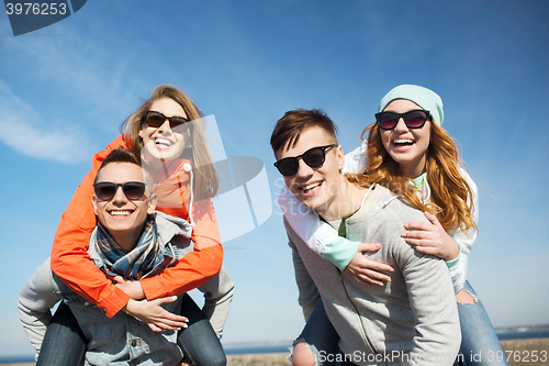 Image of happy friends in shades having fun outdoors