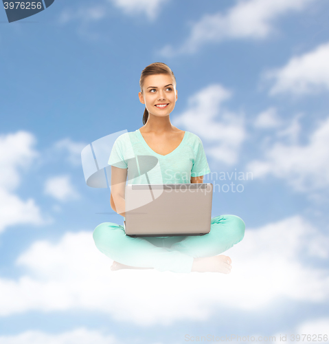 Image of happy young woman with laptop sitting on cloud