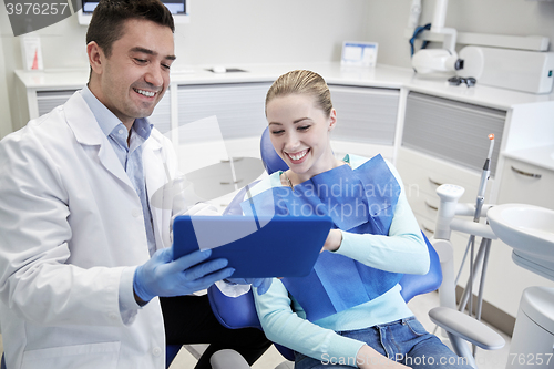 Image of male dentist with tablet pc and woman patient