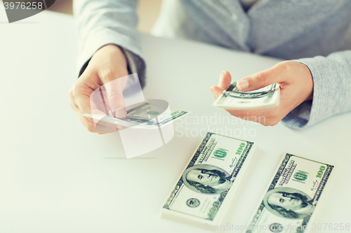 Image of close up of woman hands counting us dollar money