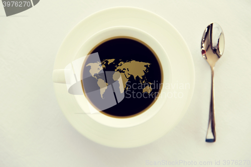 Image of world map in cup of black coffee with spoon