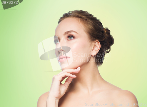 Image of beautiful young woman touching her face