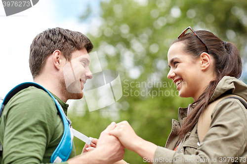 Image of happy couple with backpacks hiking outdoors