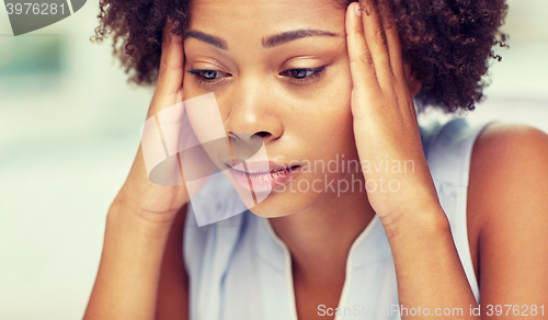 Image of close up of african young woman touching her head