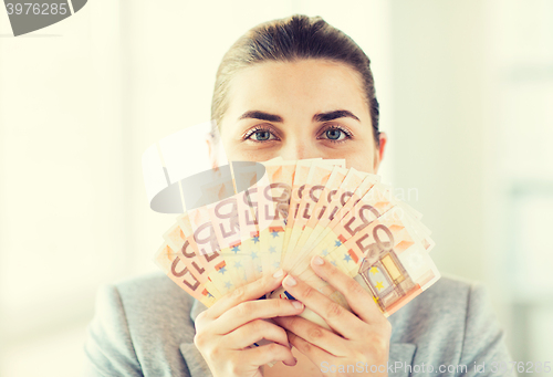 Image of woman hiding her face behind euro money fan