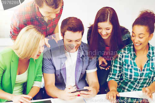 Image of students looking into smartphone at school