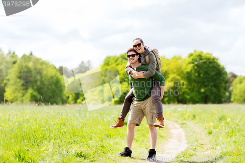 Image of happy couple with backpacks having fun outdoors