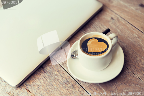 Image of close up of laptop and coffee cup with heart shape