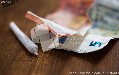 Image of close up of marijuana joint and money