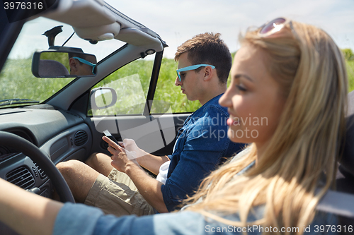 Image of man texting on smartphone driving in cabriolet car