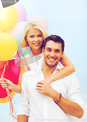 Image of couple with colorful balloons at seaside