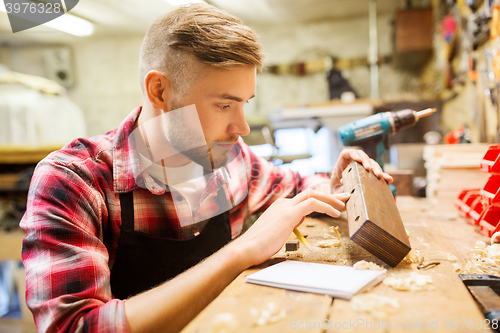 Image of carpenter working with wood plank at workshop