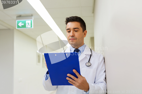 Image of doctor writing to clipboard at hospital