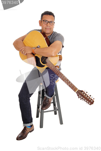 Image of Hispanic man holding his guitar.