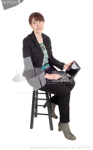 Image of Woman sitting with a laptop on her lap.