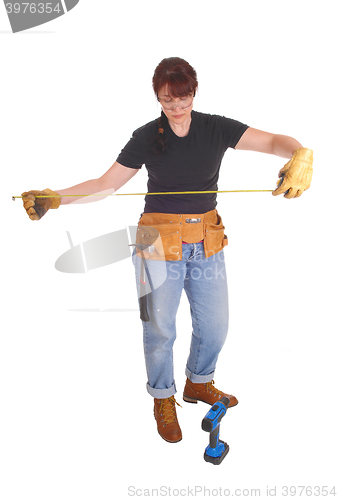 Image of A handy woman measuring for work.