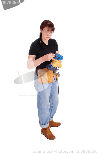 Image of Woman preparing drill for work.