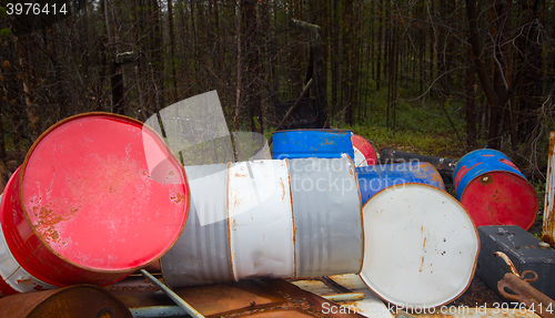 Image of Height of mismanagement and irresponsibility. Colorful empty barrel of fuel left in forest