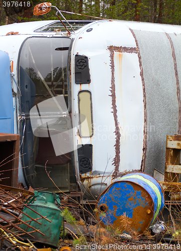 Image of Fragment of trucking dump. Old bus and empty barrels out of fuel