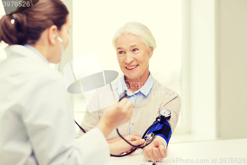 Image of doctor with tonometer and senior woman at hospital