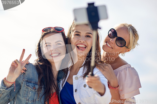 Image of group of smiling women taking selfie on beach