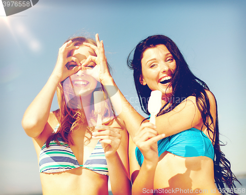 Image of girls in bikinis with ice cream on the beach