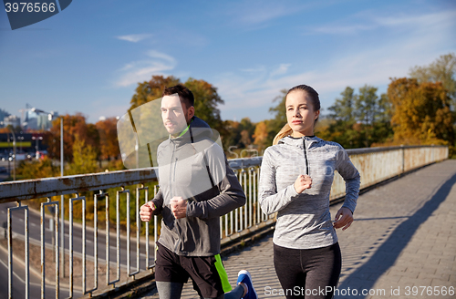 Image of happy couple running outdoors