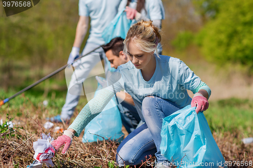 Image of volunteers with garbage bags cleaning park area