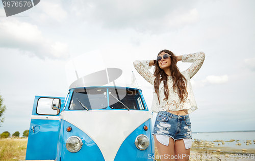 Image of smiling young hippie woman in minivan car