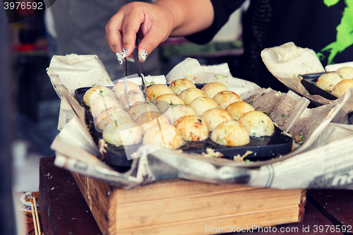 Image of close up of cook hands with meatballs at street