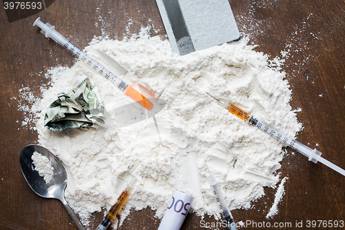 Image of close up of cocaine drug, money, spoon and syringe
