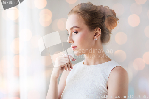 Image of smiling woman in white dress with diamond jewelry