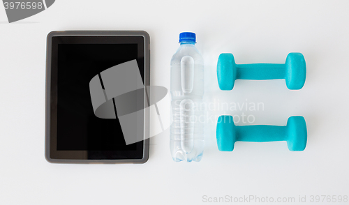 Image of close up of tablet pc, dumbbells and water bottle