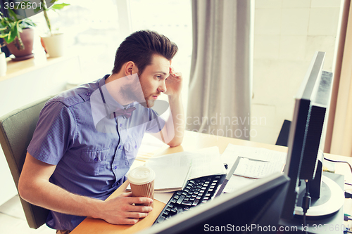 Image of creative male worker with computer drinking coffee