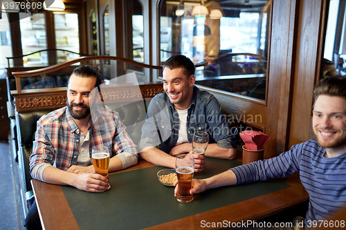 Image of happy male friends drinking beer at bar or pub