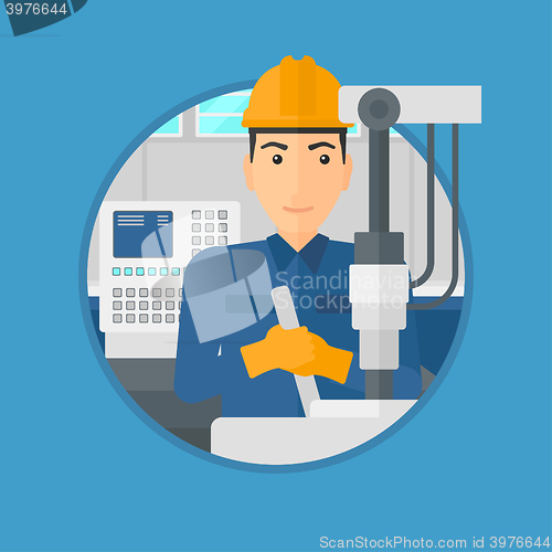 Image of Man working on industrial drilling machine.