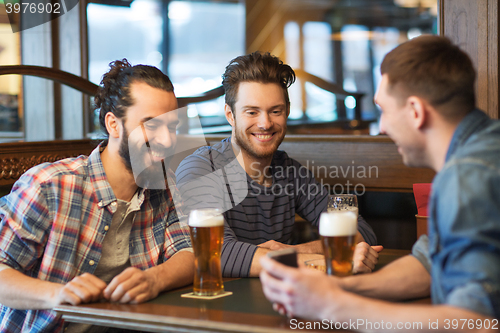 Image of male friends with smartphone drinking beer at bar