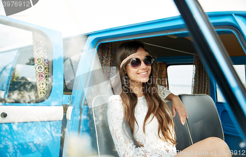 Image of smiling young hippie woman in minivan car