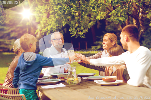 Image of happy family having holiday dinner outdoors