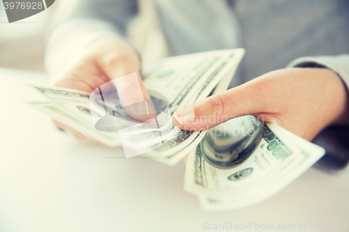 Image of close up of woman hands counting us dollar money