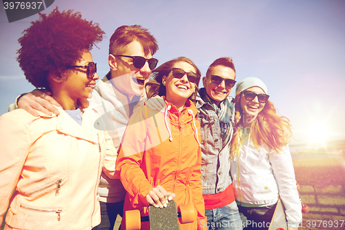 Image of happy teenage friends with longboards on street