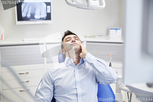 Image of man having toothache and sitting on dental chair