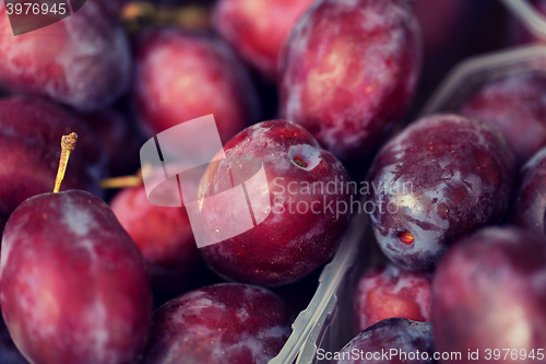 Image of close up of satsuma plums in box at street market