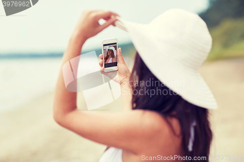 Image of young woman taking selfie with smartphone
