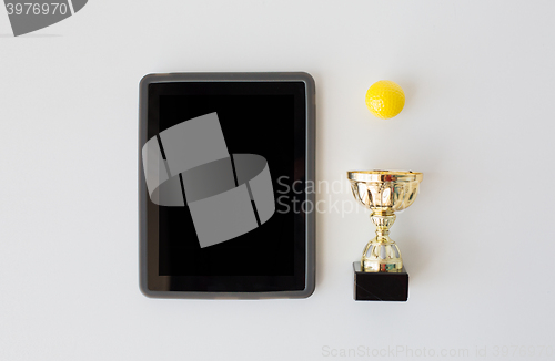 Image of close up of golf ball, cup and tablet pc