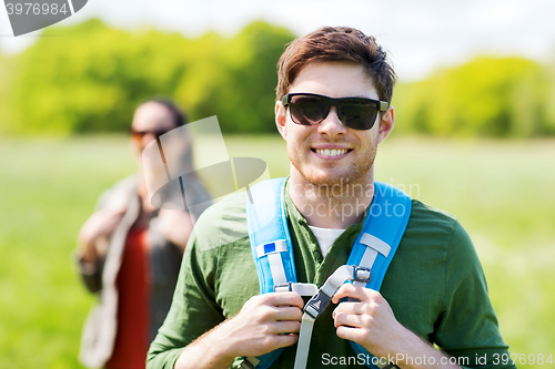 Image of happy couple with backpacks hiking outdoors