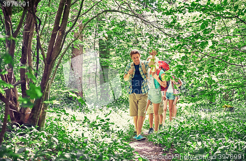 Image of group of smiling friends with backpacks hiking