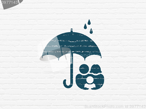 Image of Protection concept: Family And Umbrella on wall background